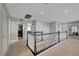 Upstairs hallway with neutral carpet and staircase with white balusters and dark wood handrail at 3632 Red Fir St, Las Vegas, NV 89135