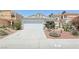 Exterior shot of home showcasing desert landscaping, a two-car garage, and neutral paint scheme at 371 Legacy Dr, Henderson, NV 89014