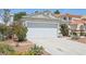 Exterior shot of home showcasing desert landscaping, a two-car garage, and neutral paint scheme at 371 Legacy Dr, Henderson, NV 89014