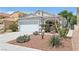 Exterior shot of home showcasing desert landscaping, a two-car garage, and neutral paint scheme at 371 Legacy Dr, Henderson, NV 89014