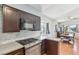 Well lit kitchen featuring stainless steel appliances, dark cabinetry, light countertops, and dining area at 371 Legacy Dr, Henderson, NV 89014