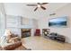 Sunlit living room boasts a cozy brick fireplace, large-screen TV, and comfortable seating area at 371 Legacy Dr, Henderson, NV 89014