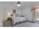 Bright bedroom with a sliding glass door, plush carpet, and modern light fixture at 3815 Atlantis St, Las Vegas, NV 89121