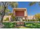 Community clubhouse featuring manicured landscaping, green grass, and shaded seating at 3815 Atlantis St, Las Vegas, NV 89121