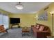 Bright living room featuring gray carpet, comfortable seating, and a mounted TV at 3815 Atlantis St, Las Vegas, NV 89121