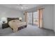 Bright main bedroom with sliding glass door to patio, ceiling fan, and neutral décor at 3815 Atlantis St, Las Vegas, NV 89121