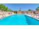 Community swimming pool with lounge chairs, a landscaped fence, and a clear blue sky at 3815 Atlantis St, Las Vegas, NV 89121