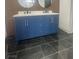 Modern bathroom featuring a stylish blue vanity with double sinks and black marble tile flooring at 3920 Aspencrest Dr, Las Vegas, NV 89108