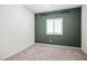 This bedroom is carpeted, has green accent wall, window with blinds at 393 Mullen Ave, Henderson, NV 89044