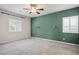 Cozy bedroom featuring carpet floors, accent wall, ceiling fan, and window with shutters at 393 Mullen Ave, Henderson, NV 89044