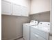 Bright laundry room with white cabinets, shelf and front loading machines at 393 Mullen Ave, Henderson, NV 89044