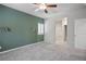 Cozy bedroom featuring carpet floors, accent wall, ceiling fan, and a bathroom at 393 Mullen Ave, Henderson, NV 89044