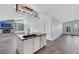 Open kitchen with island, stainless steel appliances, and modern lighting fixtures at 4143 Chela Cir, Las Vegas, NV 89120