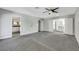 Spacious living room showcasing the neutral walls, carpet flooring, ceiling fan, and entryways at 4143 Chela Cir, Las Vegas, NV 89120
