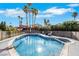 A sparkling pool is fenced for safety and set against a backdrop of mature palm trees at 4143 Chela Cir, Las Vegas, NV 89120