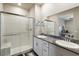 Well-lit bathroom with dual sinks, glass-enclosed shower, and granite countertops at 42 Late Harvest Ave, Pahrump, NV 89060