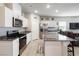 Modern kitchen with stainless steel appliances, white cabinets, a large island and granite countertops at 42 Late Harvest Ave, Pahrump, NV 89060