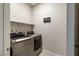 Convenient laundry room with front loading washer/dryer, shelving, and 'The Laundry Room' decorative wall sign at 42 Late Harvest Ave, Pahrump, NV 89060