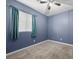Cozy bedroom featuring neutral carpet, blue walls, and a window with curtains at 4308 Brazil Palm Ct, North Las Vegas, NV 89032