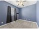 Bedroom featuring neutral carpet, blue walls, and a window with curtains at 4308 Brazil Palm Ct, North Las Vegas, NV 89032