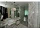 Contemporary bathroom with dual sinks, a glass shower, and stylish marble tile throughout at 4381 W Flamingo Rd # 1508, Las Vegas, NV 89103