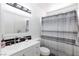 Bathroom featuring a double sink vanity with black accent tile and tub with striped shower curtain at 459 Kelsford Dr, Las Vegas, NV 89123