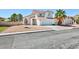 A two-story home features low maintenance landscaping, a tile roof and a two-car garage at 459 Kelsford Dr, Las Vegas, NV 89123