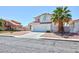 A two-story home features low maintenance landscaping, a tile roof and a two-car garage at 459 Kelsford Dr, Las Vegas, NV 89123