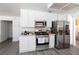 The kitchen has stainless steel appliances, gray wood-look flooring, and white cabinets at 459 Kelsford Dr, Las Vegas, NV 89123