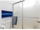 Close-up of shower with frosted glass doors, toilet, and blue and grey towels at 459 Kelsford Dr, Las Vegas, NV 89123