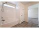 Bathroom with shower-tub combination, white tile surround, and window for natural light at 4610 Lime Straight Dr, Las Vegas, NV 89115