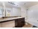 Bathroom featuring granite counter vanity, large mirror and tub-shower combo with white tile at 4610 Lime Straight Dr, Las Vegas, NV 89115