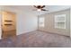 Bright bedroom with a ceiling fan, plush carpeting, two windows with blinds and a walk-in closet at 4610 Lime Straight Dr, Las Vegas, NV 89115