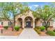 Elegant clubhouse entrance with arched entryway, manicured landscaping, and a welcoming pathway at 4610 Lime Straight Dr, Las Vegas, NV 89115