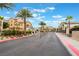 Gated community entrance with lush landscaping and palm tree lined street at 4610 Lime Straight Dr, Las Vegas, NV 89115