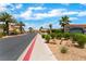 A view of a gated community entrance surrounded by mature landscaping at 4610 Lime Straight Dr, Las Vegas, NV 89115