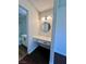 Modern bathroom vanity features a round mirror and shiplap accent wall at 5260 Mission Monterey Ln # 208, Las Vegas, NV 89107