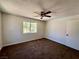 Spacious bedroom featuring a ceiling fan, a large window and neutral brown carpet at 5260 Mission Monterey Ln # 208, Las Vegas, NV 89107