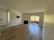 Bright living room featuring wood-look floors, fireplace, and sliding glass doors to a balcony at 5260 Mission Monterey Ln # 208, Las Vegas, NV 89107