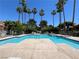 Community pool lined with palm trees and lounge chairs for relaxing at 5260 Mission Monterey Ln # 208, Las Vegas, NV 89107