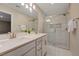 Modern bathroom with dual sinks, quartz countertops, framed mirror and glass-enclosed shower at 5299 Silver Branch Ave, Las Vegas, NV 89118