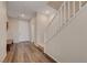 Hallway featuring wood-look floors, a staircase with white railing, and neutral walls at 5299 Silver Branch Ave, Las Vegas, NV 89118