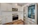 A modern kitchen has stainless steel appliances, white cabinets, and countertops with dark wood flooring at 5299 Silver Branch Ave, Las Vegas, NV 89118