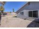 Gravel backyard with block wall and partially covered patio, offering space for outdoor activities at 5535 Oxbow St, Las Vegas, NV 89119