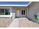 Close up of a home's front entrance, featuring a white door, rock landscaping, and modern architectural accents at 5535 Oxbow St, Las Vegas, NV 89119