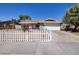 Charming single-story home with a white picket fence, lush landscaping, and a two-car garage at 5535 Oxbow St, Las Vegas, NV 89119