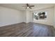 Neutral living room featuring updated flooring, a large window, ceiling fan, and white trim at 5535 Oxbow St, Las Vegas, NV 89119