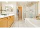 Bathroom featuring double sink vanity, tub, glass shower, and tile flooring, providing a spacious and relaxing retreat at 561 Fork Mesa Ct, Henderson, NV 89015