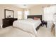 Bright bedroom with carpet floors featuring a large bed with two bedside tables and a dark wood dresser at 561 Fork Mesa Ct, Henderson, NV 89015