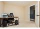 Bright bedroom with carpet floors featuring a small desk with an office chair and a door that leads to the hallway at 561 Fork Mesa Ct, Henderson, NV 89015